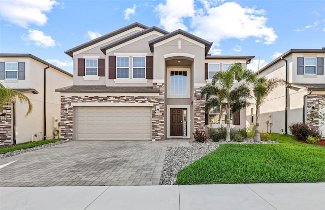 3071 Marine Grass Dr, Wimauma, FL 33598 - view of front facade featuring stone siding, decorative driveway, stucco siding, and a garage