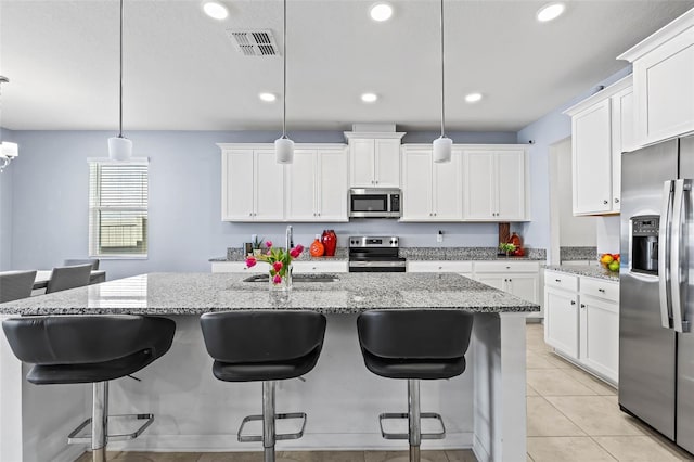 3071 Marine Grass Dr, Wimauma, FL 33598 - kitchen featuring appliances with stainless steel finishes, a sink, white cabinets, recessed lighting, and a center island