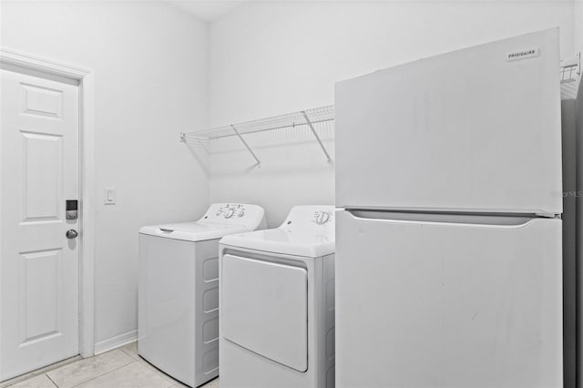 3071 Marine Grass Dr, Wimauma, FL 33598 - laundry room with washer and dryer, light tile patterned floors, and baseboards