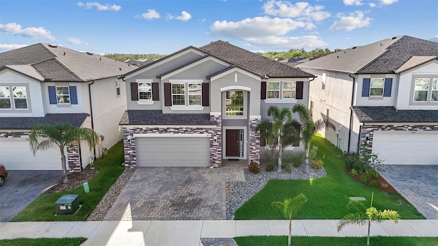 3071 Marine Grass Dr, Wimauma, FL 33598 - traditional-style home with stucco siding, decorative driveway, an attached garage, a front yard, and stone siding