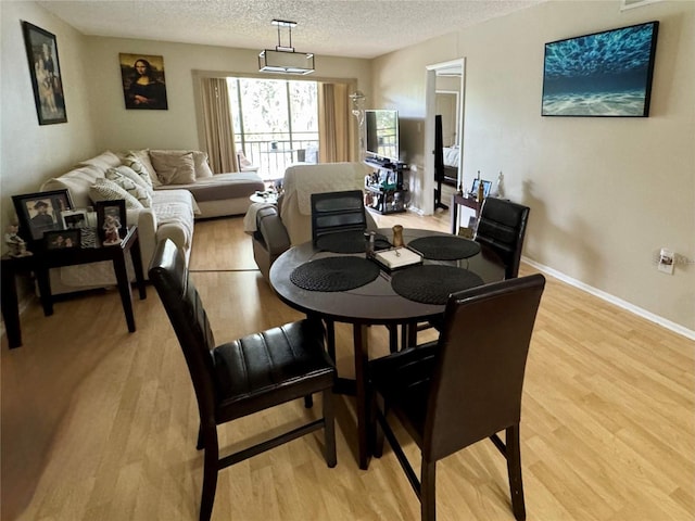 220 Cypress Ln Unit 220, Oldsmar, FL 34677 - dining room featuring a textured ceiling, light wood-style flooring, and baseboards