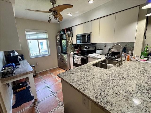 220 Cypress Ln Unit 220, Oldsmar, FL 34677 - kitchen featuring appliances with stainless steel finishes, a sink, a ceiling fan, light stone counters, and decorative backsplash