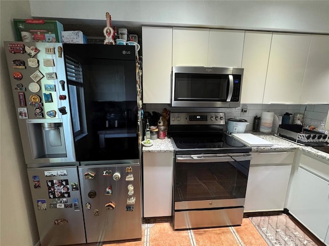 220 Cypress Ln Unit 220, Oldsmar, FL 34677 - kitchen featuring stainless steel appliances, white cabinets, backsplash, and light stone countertops