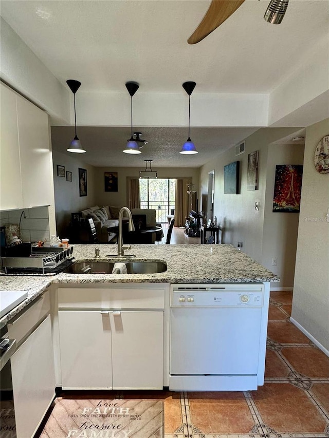 220 Cypress Ln Unit 220, Oldsmar, FL 34677 - kitchen featuring white dishwasher, white cabinets, a peninsula, a sink, and hanging light fixtures