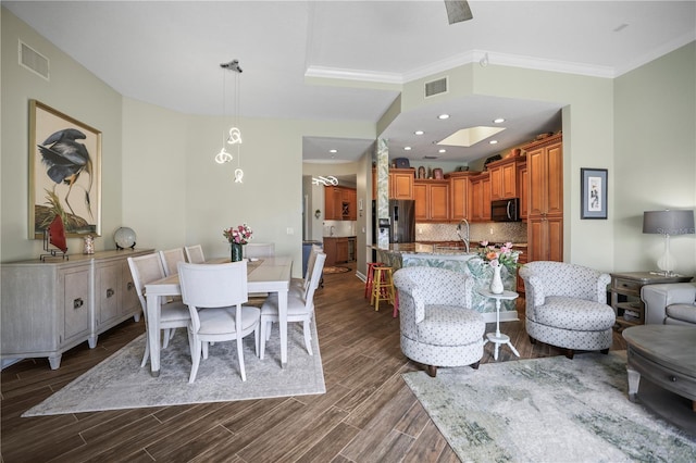 205 Brightwater Dr Unit 101, Clearwater Beach, FL 33767 - dining room featuring dark wood-style flooring and ornamental molding