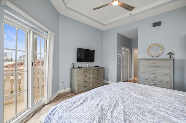 205 Brightwater Dr Unit 101, Clearwater Beach, FL 33767 - bedroom featuring access to outside, light wood-style flooring, baseboards, a ceiling fan, and a tray ceiling