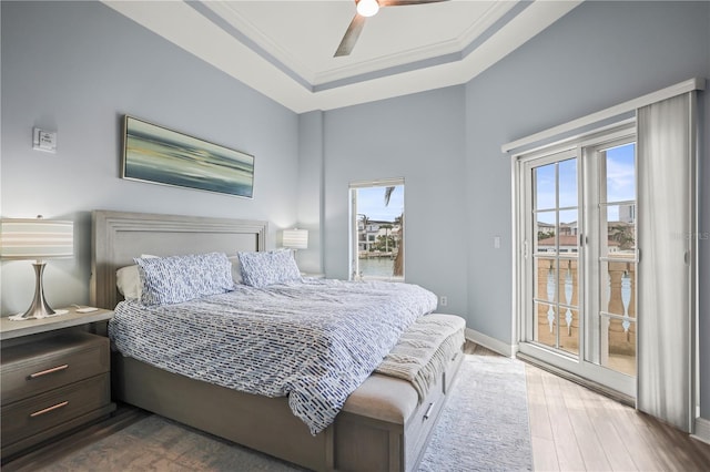 205 Brightwater Dr Unit 101, Clearwater Beach, FL 33767 - bedroom with access to outside, dark wood-style flooring, baseboards, a raised ceiling, and a ceiling fan