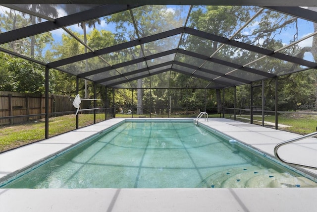 view of swimming pool featuring a fenced backyard and glass enclosure