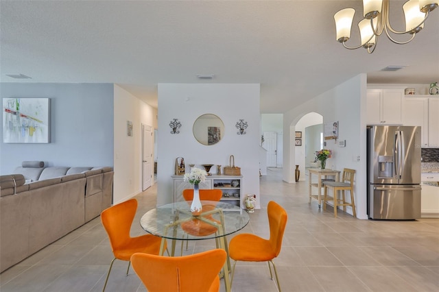 11924 Brighton Knoll Loop, Riverview, FL 33579 - dining space featuring a chandelier, light tile patterned floors, and arched walkways