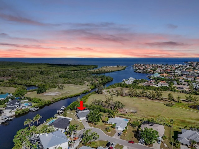 aerial view at dusk of a water view and a residential view
