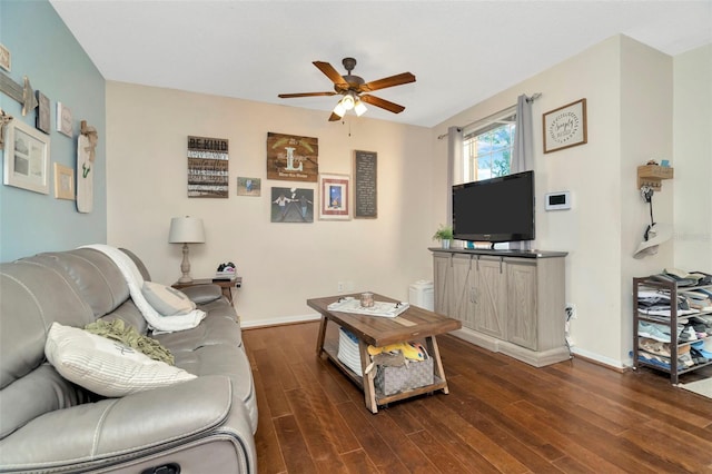 living area featuring a ceiling fan, dark wood-type flooring, and baseboards