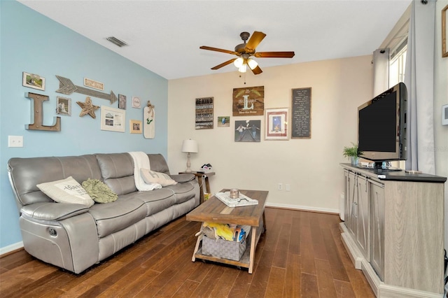 living area featuring ceiling fan, dark wood-style floors, and baseboards