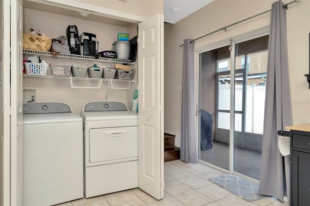 clothes washing area featuring washing machine and dryer and light tile patterned floors