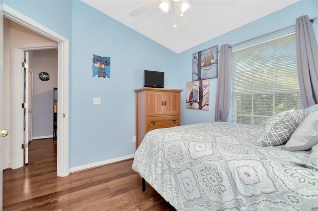 bedroom featuring wood finished floors, lofted ceiling, baseboards, and a ceiling fan