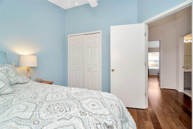 bedroom with a high ceiling, a closet, and dark wood-style flooring