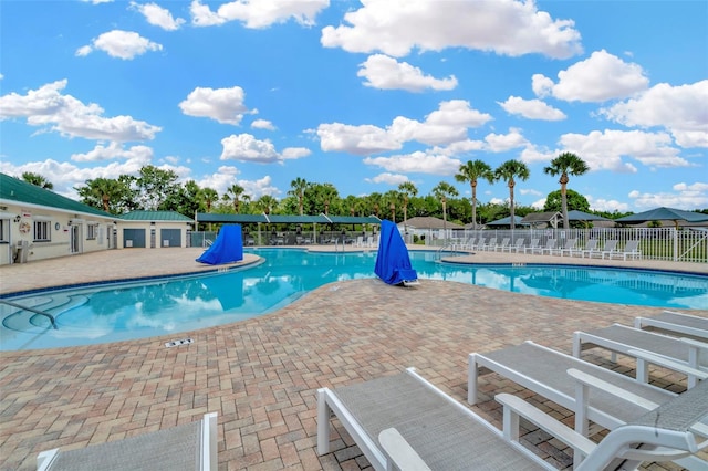 community pool featuring fence and a patio