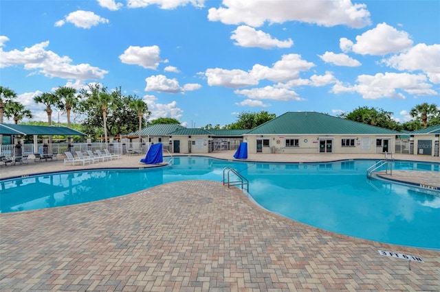 community pool with fence and a patio area