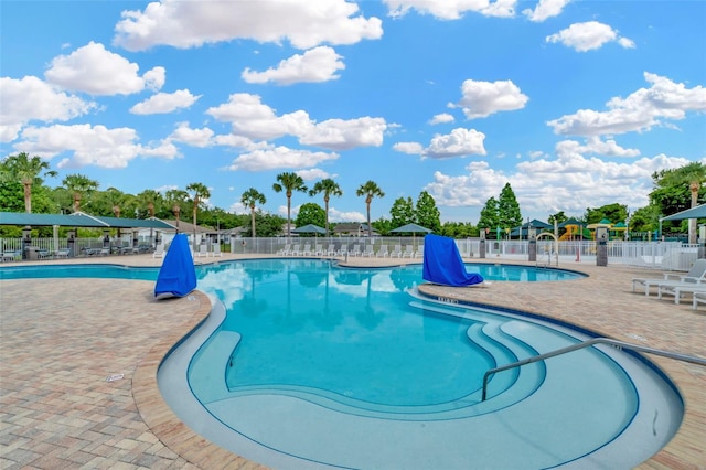 community pool with fence and a patio