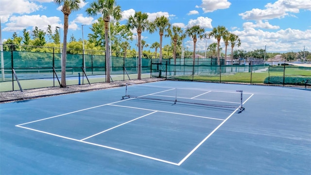 view of tennis court featuring fence
