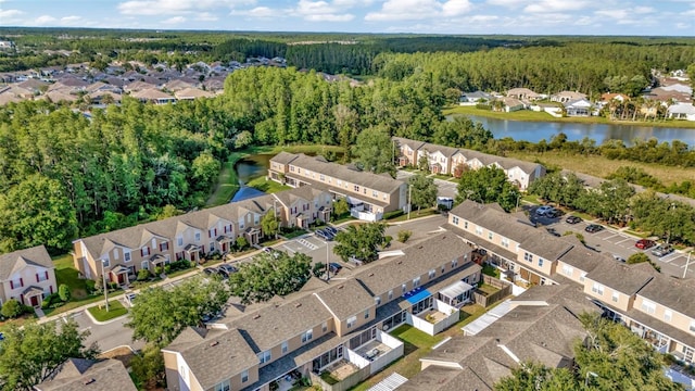 aerial view of residential area featuring a large body of water and a forest
