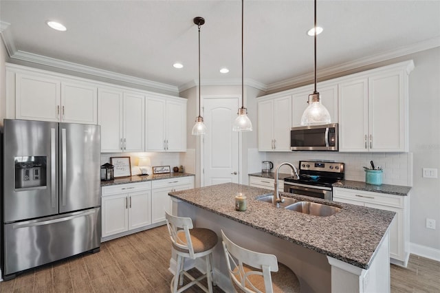 764 W Bayshore Dr, Tarpon Springs, FL 34689 - kitchen with stainless steel appliances, light wood finished floors, backsplash, a kitchen island with sink, and crown molding