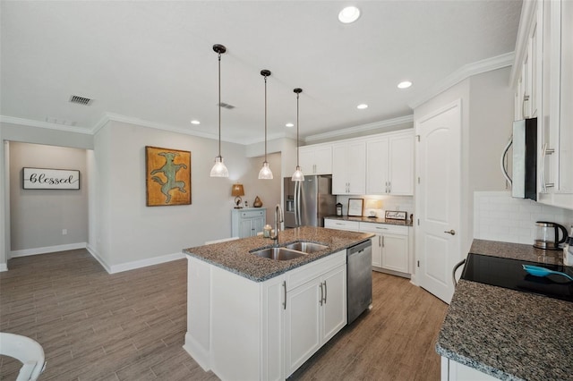 764 W Bayshore Dr, Tarpon Springs, FL 34689 - kitchen with a sink, appliances with stainless steel finishes, an island with sink, wood finished floors, and ornamental molding