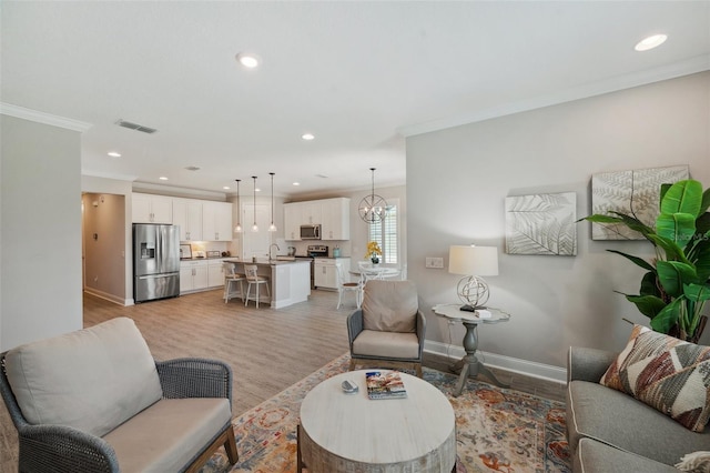 764 W Bayshore Dr, Tarpon Springs, FL 34689 - living area featuring ornamental molding, light wood-style flooring, recessed lighting, baseboards, and a chandelier