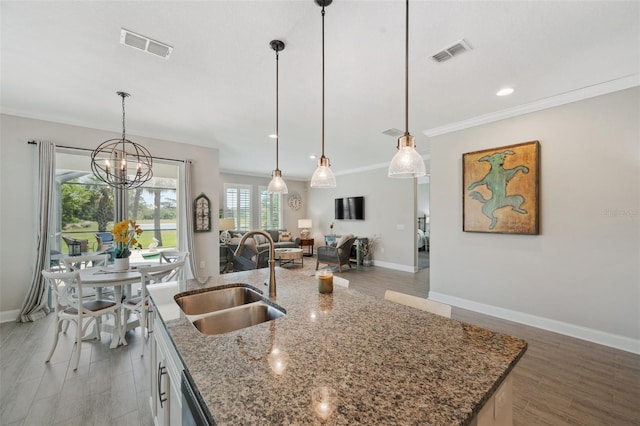 764 W Bayshore Dr, Tarpon Springs, FL 34689 - kitchen featuring a sink, open floor plan, baseboards, a center island with sink, and light wood-style flooring