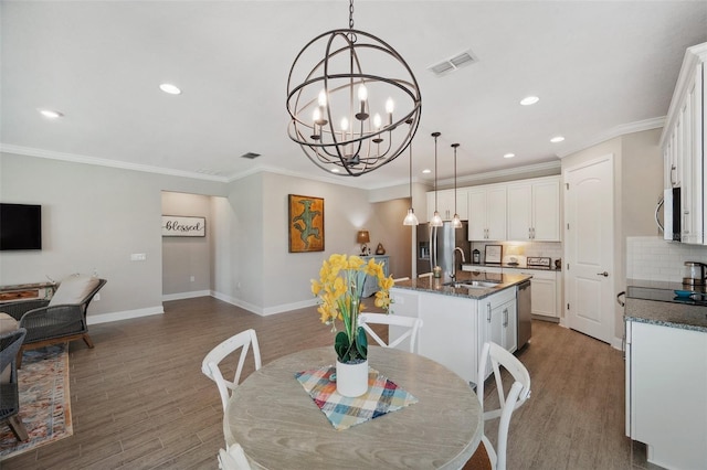 764 W Bayshore Dr, Tarpon Springs, FL 34689 - dining area featuring wood finished floors, recessed lighting, baseboards, a chandelier, and crown molding