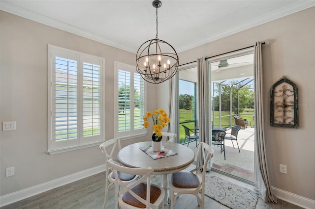 764 W Bayshore Dr, Tarpon Springs, FL 34689 - dining room with healthy amount of natural light, crown molding, baseboards, and a chandelier