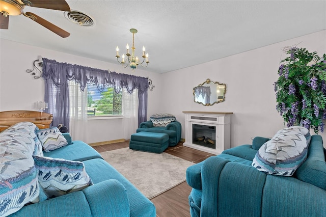6801 Pinellas Point Dr S, Saint Petersburg, FL 33712 - living room with a chandelier, wood finished floors, a glass covered fireplace, ceiling fan, and baseboards