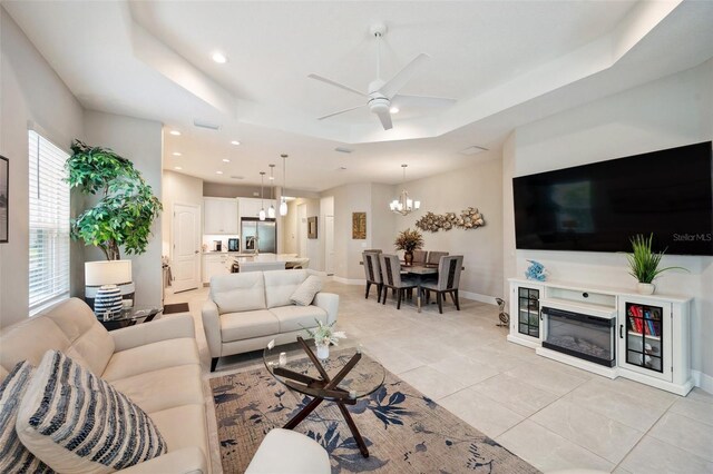 12817 Cobalt Ter, Bradenton, FL 34211 - living room featuring a chandelier, a ceiling fan, light tile patterned flooring, recessed lighting, and a tray ceiling