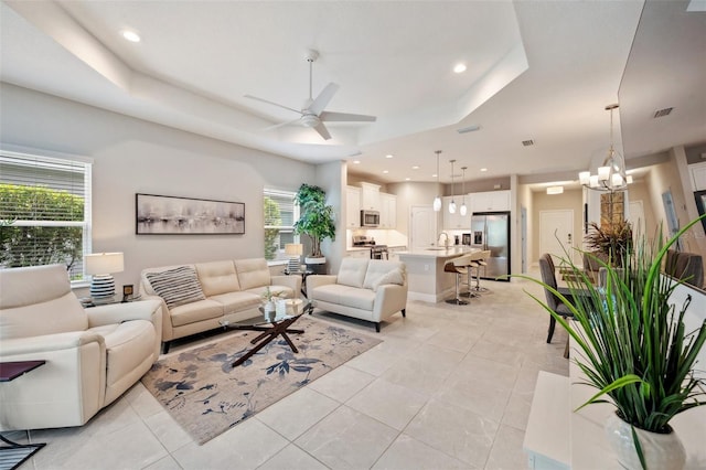 12817 Cobalt Ter, Bradenton, FL 34211 - living area featuring ceiling fan, a tray ceiling, light tile patterned flooring, a chandelier, and recessed lighting