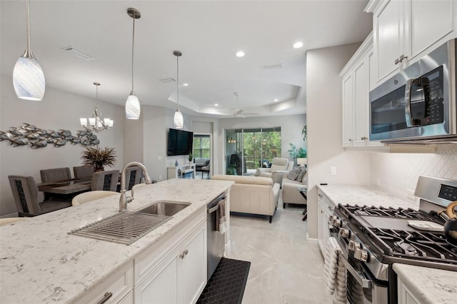 12817 Cobalt Ter, Bradenton, FL 34211 - kitchen featuring stainless steel appliances, a sink, light stone countertops, tasteful backsplash, and white cabinetry