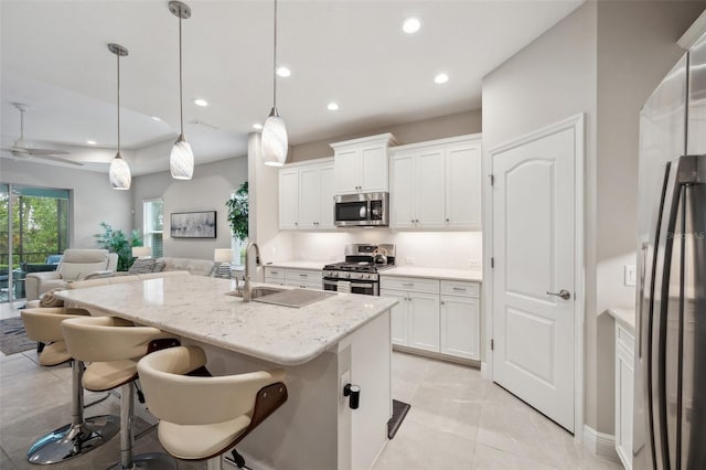 12817 Cobalt Ter, Bradenton, FL 34211 - kitchen with stainless steel appliances, open floor plan, an island with sink, white cabinetry, and recessed lighting