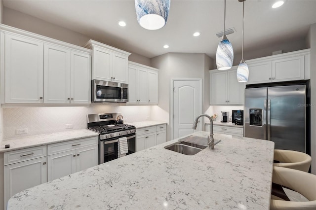 12817 Cobalt Ter, Bradenton, FL 34211 - kitchen featuring appliances with stainless steel finishes, a sink, a breakfast bar area, hanging light fixtures, and white cabinetry