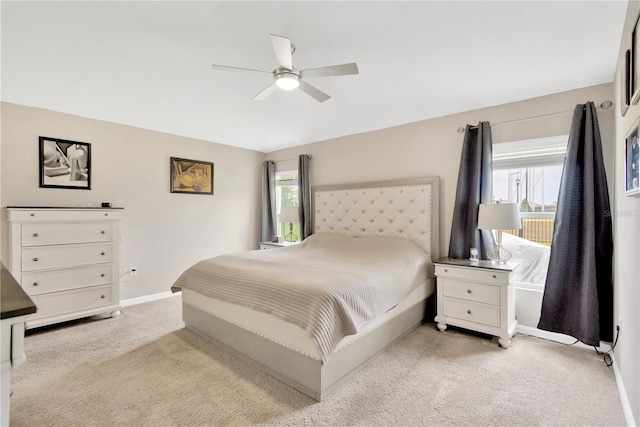 bedroom with light carpet, baseboards, and a ceiling fan