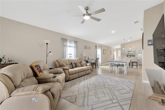 living room with a ceiling fan, light wood-style flooring, high vaulted ceiling, recessed lighting, and baseboards