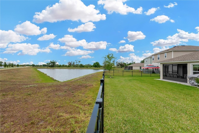 view of yard featuring a sunroom and a water view