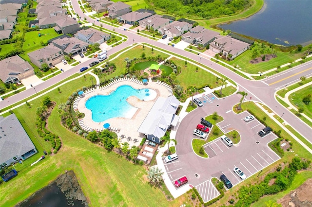 aerial view of residential area featuring a pool area and a large body of water