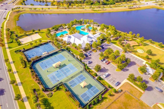 drone / aerial view of a pool and a nearby body of water