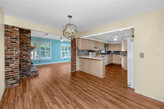 6536 115th Ln, Seminole, FL 33772 - kitchen featuring a chandelier, white appliances, wood finished floors, baseboards, and a peninsula