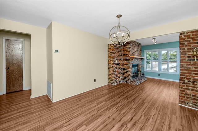 6536 115th Ln, Seminole, FL 33772 - unfurnished living room with wood finished floors, a chandelier, a fireplace, and baseboards