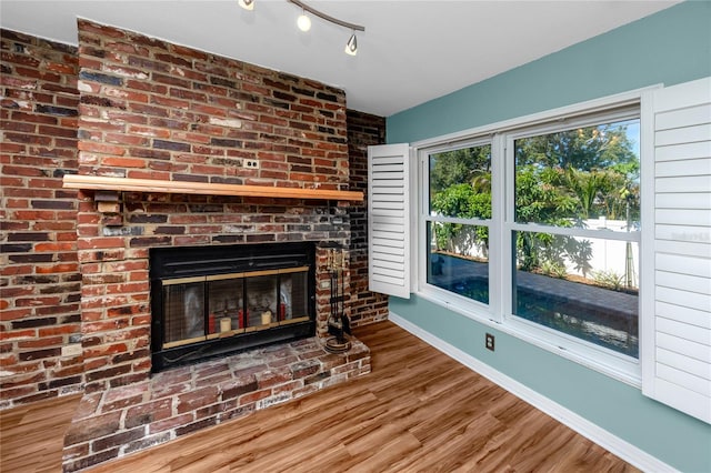 6536 115th Ln, Seminole, FL 33772 - unfurnished living room featuring baseboards, wood finished floors, and a fireplace