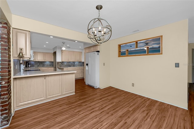 6536 115th Ln, Seminole, FL 33772 - kitchen with white appliances, light wood-type flooring, a chandelier, decorative backsplash, and a sink