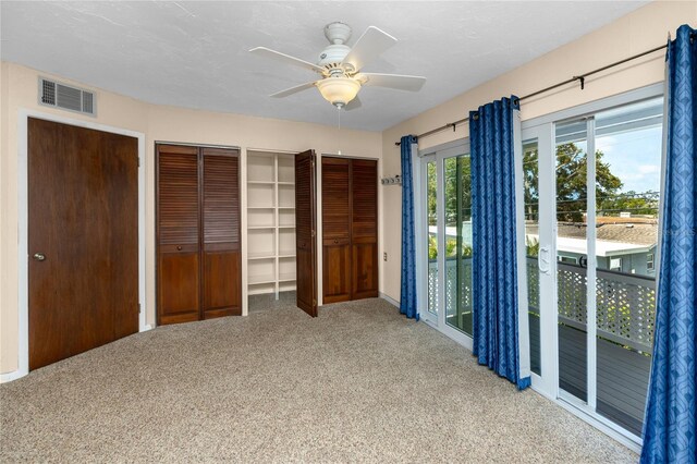 6536 115th Ln, Seminole, FL 33772 - unfurnished bedroom featuring access to outside, carpet floors, two closets, and ceiling fan