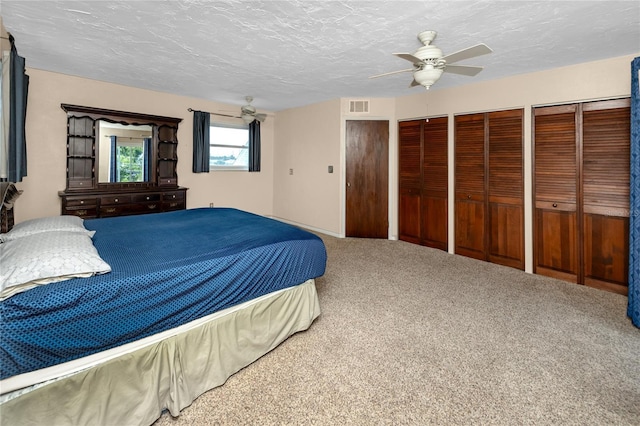 6536 115th Ln, Seminole, FL 33772 - carpeted bedroom featuring two closets, a textured ceiling, and ceiling fan
