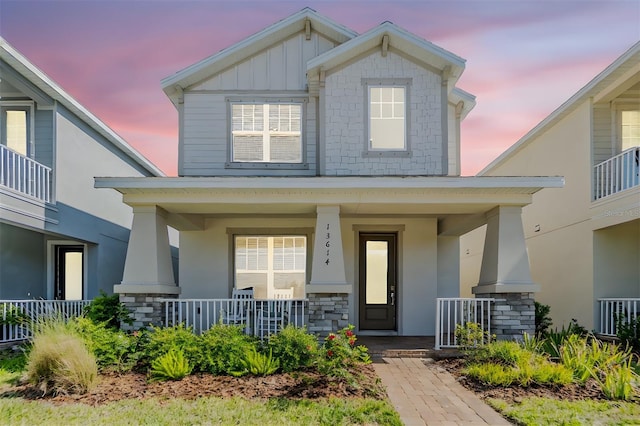 13614 Stevenson Ln, Odessa, FL 33556 - view of front of home featuring a porch, stone siding, and board and batten siding