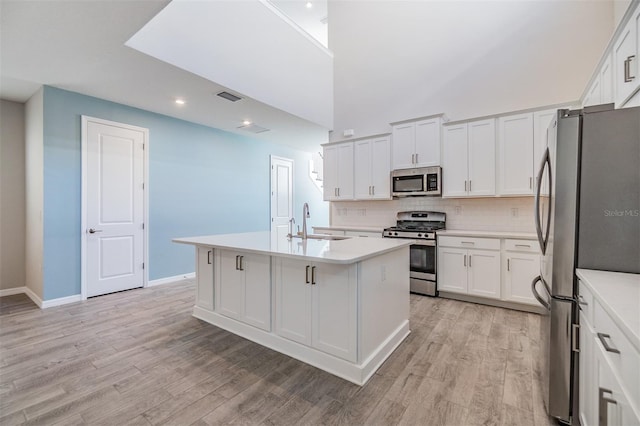 13614 Stevenson Ln, Odessa, FL 33556 - kitchen with stainless steel appliances, a sink, light countertops, light wood-type flooring, and recessed lighting