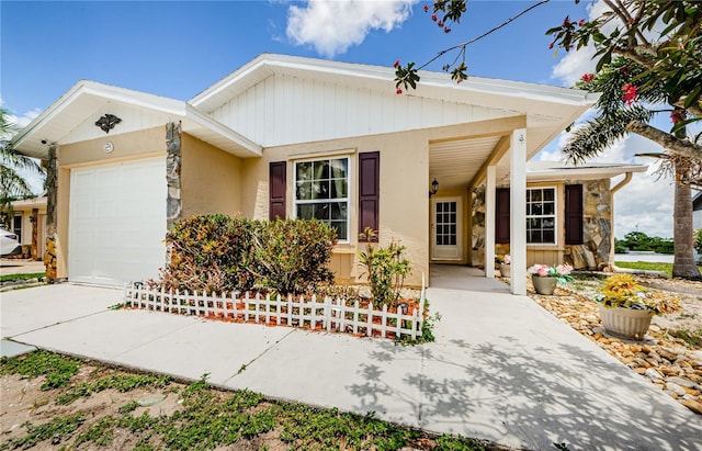 699 Merlins Ct, Tarpon Springs, FL 34689 - view of front of house with a garage, driveway, stone siding, and stucco siding